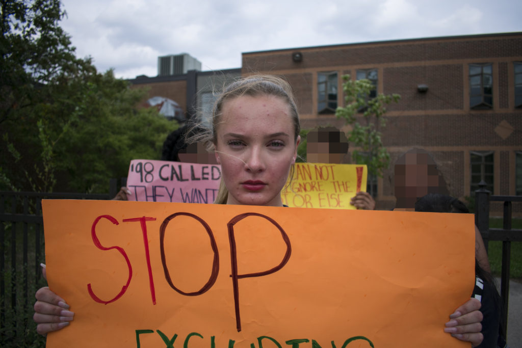 Quinne Kendall-Mitchell, a grade 10 student from East York Collegiate Institute, holds a sign in protest of the province's decision to scrap the updated 2015 sex-ed curriculum.