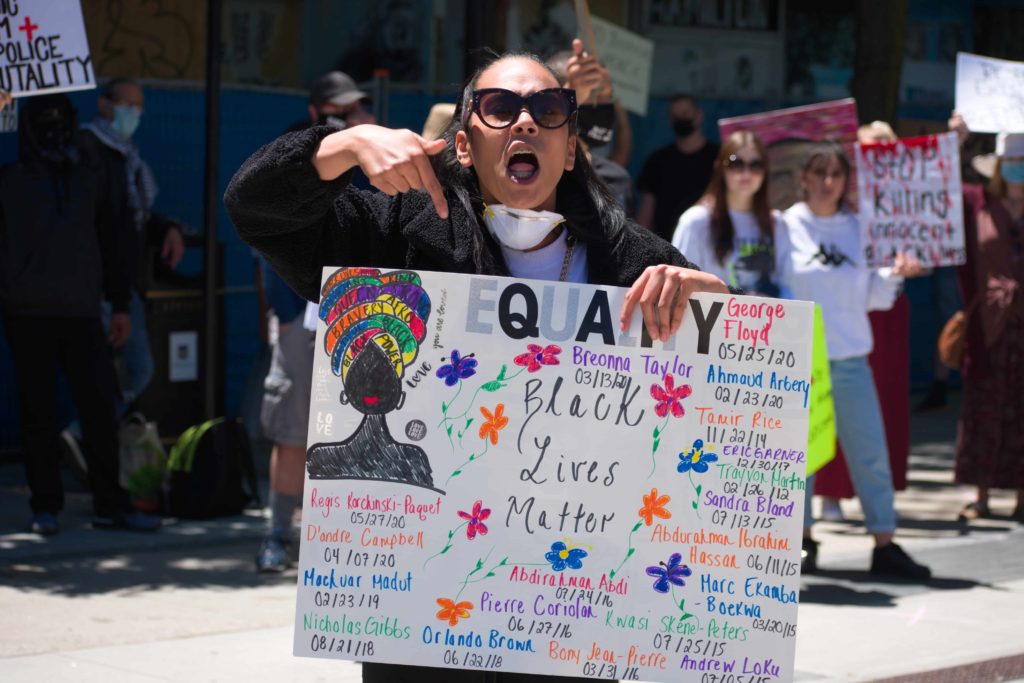 A Black Lives Matter activist screams and waves a sign